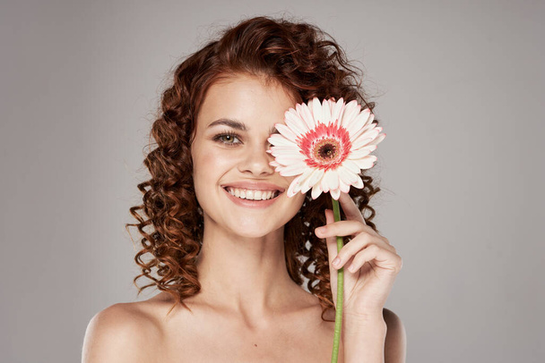 Młoda kobieta z kwiatem pozowanie w studio - Zdjęcie, obraz