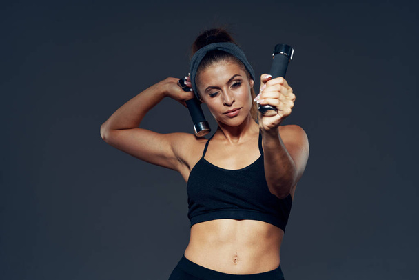Athletic woman exercising with dumbbells. Studio shot  - Foto, Imagem