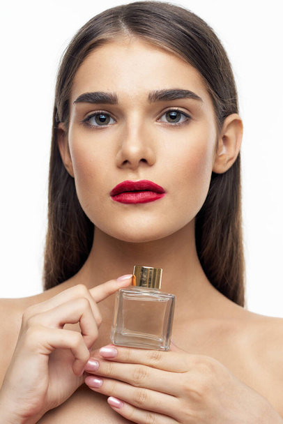Junge schöne Frau hält Parfümflasche im Atelier - Foto, Bild