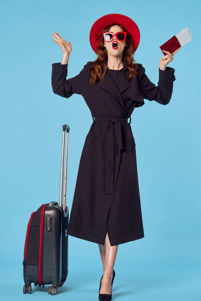 Молодая женщина с красным чемоданом в студии
 - Фото, изображение