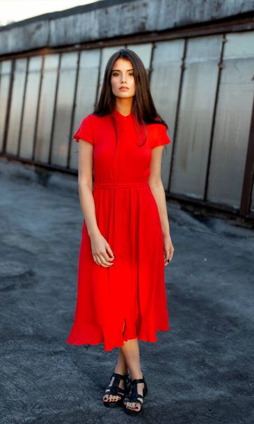 Full length portrait of attractive beautiful girl in a red dress with brown straight hair, looking at camera. - Fotó, kép