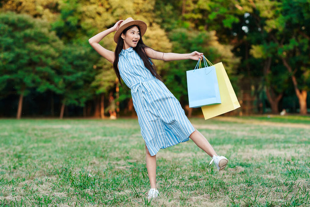 Young asian woman posing with shopping bags  - 写真・画像