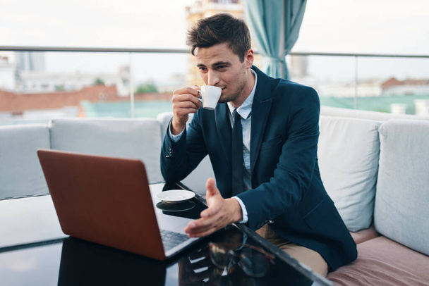 joven hombre de negocios guapo que trabaja con el ordenador portátil en la cafetería - Foto, Imagen