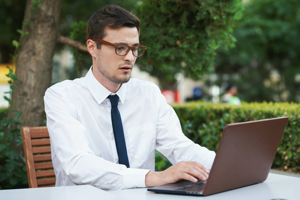 Young handsome businessman sitting in cafe  with laptop computer - Foto, Bild