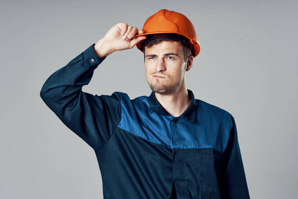 Студийный снимок Молодой рабочий в оранжевом шлеме - Фото, изображение