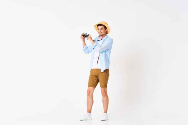 νεαρός όμορφος άντρας τουρίστας με κάμερα στο στούντιο - Φωτογραφία, εικόνα