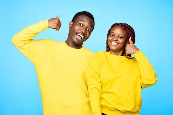 hombre y mujer de apariencia africana con pulgares hacia arriba sobre fondo aislado - Foto, Imagen