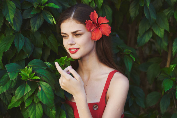 Young beautiful woman posing with flower in her hair - Foto, Imagen