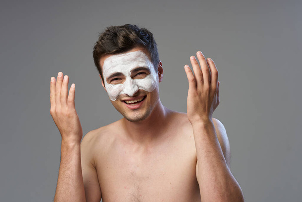 Young handsomen man appying face mask. studio shot - Photo, Image