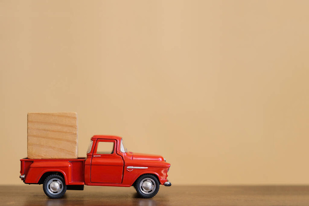 Red retro toy truck with a wooden cube in the back. - 写真・画像