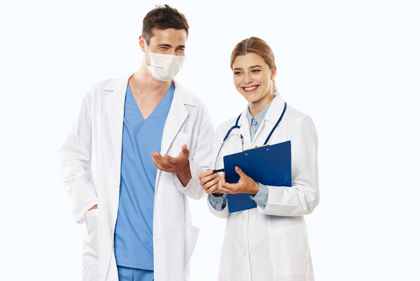 Jonge artsen in studio glimlachend, geïsoleerde achtergrond.  - Foto, afbeelding