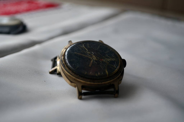 Σπασμένο χρυσό σοβιετικό ρολόι στο τραπέζι - Φωτογραφία, εικόνα