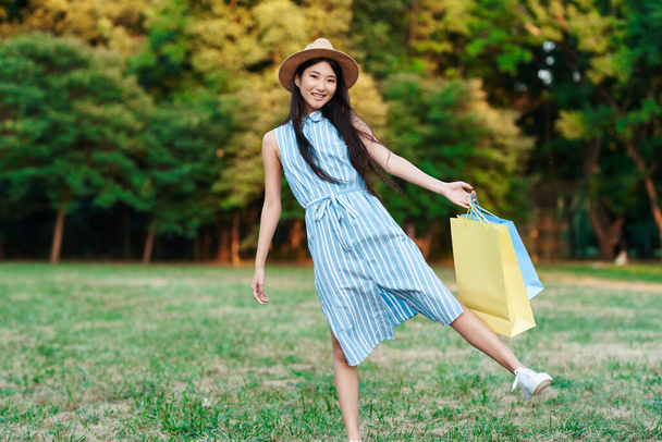 young with shopping bags  walking  in the park. - 写真・画像
