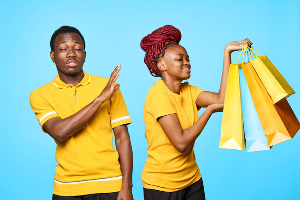 mężczyzna i kobieta afrykańskiego wyglądu z torbami na zakupy na odosobnionym tle - Zdjęcie, obraz