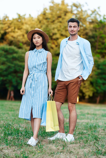 pareja joven con bolsas de compras en el parque
 - Foto, Imagen