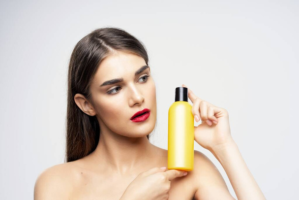 Young beautiful woman with beauty product  in studio  - Fotó, kép