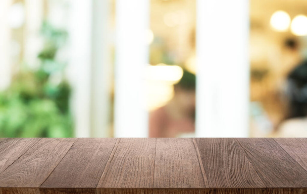 Table en bois sombre vide devant un fond bokeh abstrait flou du restaurant. peut être utilisé pour afficher ou monter vos produits.Maquette pour l'espace  - Photo, image