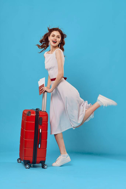 Young woman with red suitcase in studio - Fotoğraf, Görsel