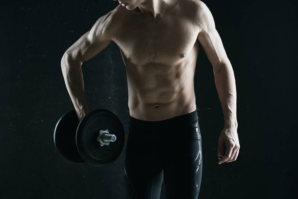 Young man with dumbbell in studio  - Foto, Imagem