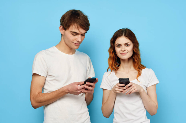 молодая пара со смартфонами в студии  - Фото, изображение