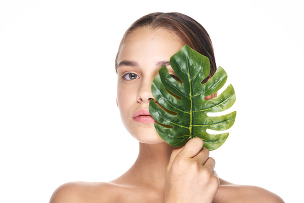 Young beautiful wman  posing with leaf in studio - Foto, imagen