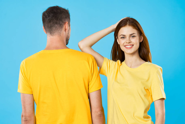 young beautiful couple in  t-shirts posing in studio on isolated background - Fotó, kép