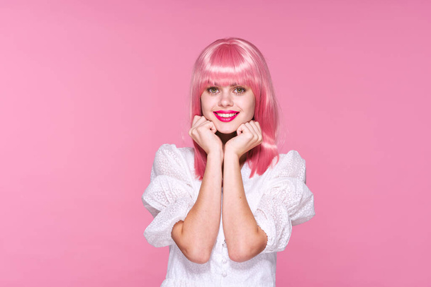 νεαρή όμορφη γυναίκα με ροζ περούκα ποζάρει στο στούντιο  - Φωτογραφία, εικόνα