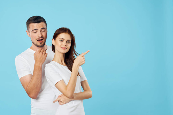 Young  couple  in studio pointing on isolated background - Foto, Imagem