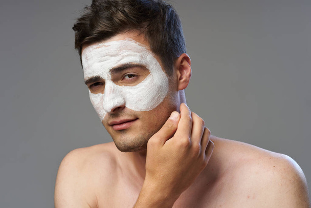 Young man applying facial mask  - 写真・画像