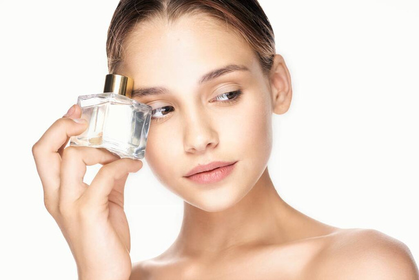 Retrato de mujer joven y hermosa con frasco de perfume aislado sobre fondo blanco
 - Foto, imagen