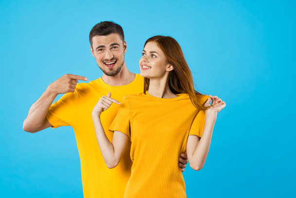 young man  pointing woman  woman in studio  on blue background  - Photo, Image