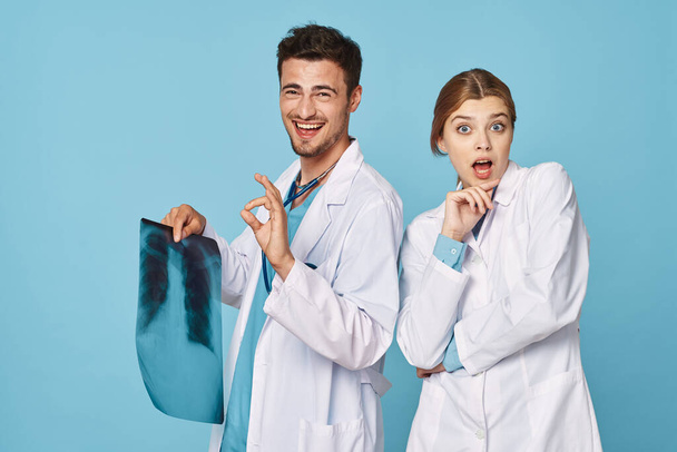 лікарі з рентгенівським випромінюванням в студії ізольовані на синьому
 - Фото, зображення