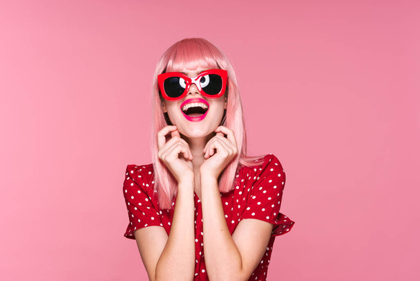 jong mooi vrouw in roze pruik en zonnebril poseren in studio  - Foto, afbeelding