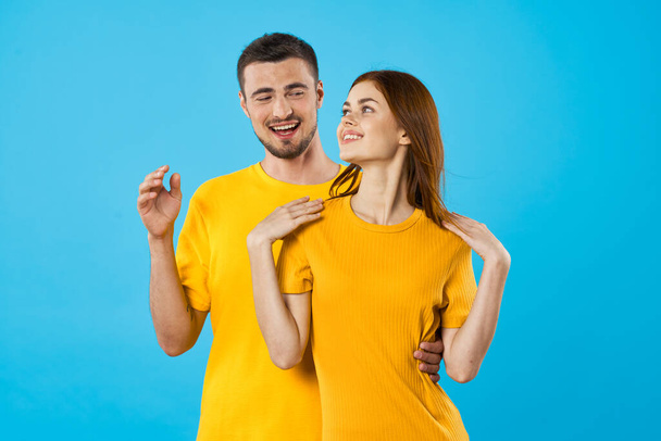 young woman and man smiling  on blue background  - Foto, Imagen