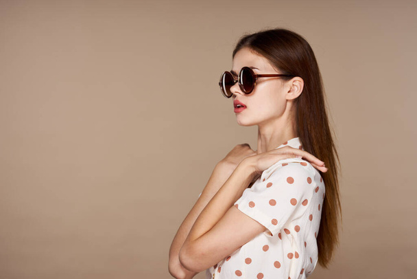młoda piękna kobieta w okularach przeciwsłonecznych pozowanie w studio  - Zdjęcie, obraz