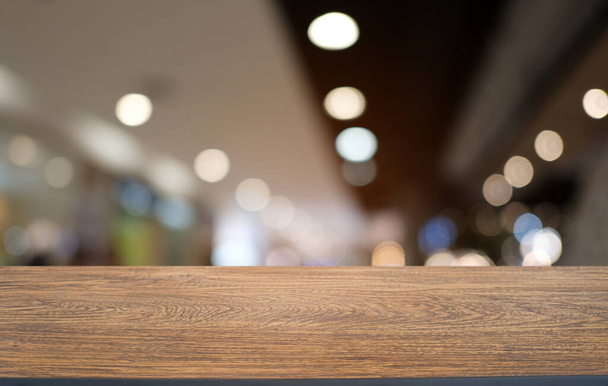 レストランの抽象的なぼやけたボケの背景の前に空の暗い木製のテーブル。製品の表示やモンタージュに使用できます。  - 写真・画像