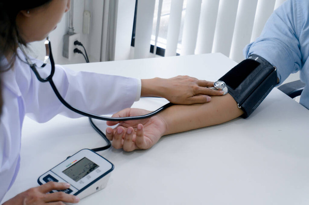 Dokter controleert oude vrouw patiënt arteriële bloeddruk. Gezondheidszorg. - Foto, afbeelding