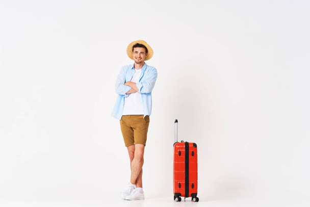 Jeune homme avec valise rouge en studio - Photo, image