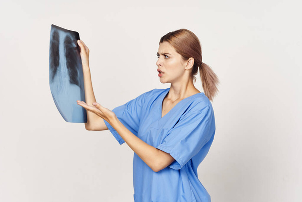confused woman doctor examining x-ray. Studio shot - Photo, Image