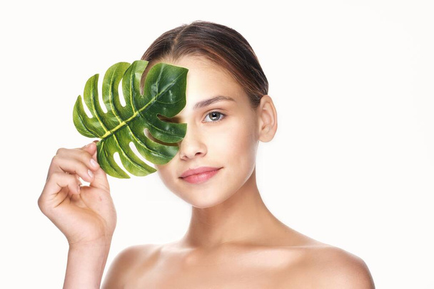 Young beautiful wman  posing with leaf in studio - Foto, Imagem