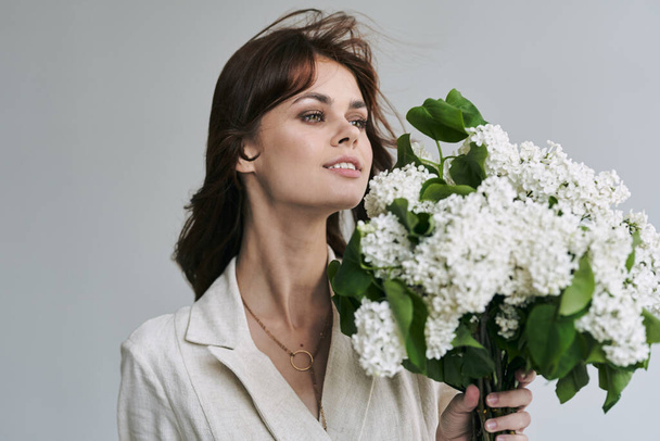 Young beautiful woman with lilacs in studio - 写真・画像