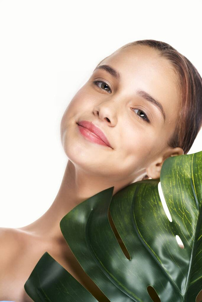Young beautiful wman  posing with leaf in studio - Foto, imagen