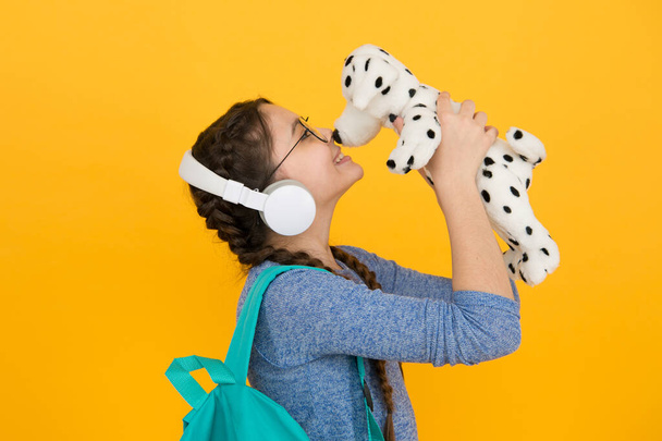 Cute smiling schoolgirl carry soft toy dog. Girl little schoolgirl. Modern schoolgirl daily life. Private schooling. Diverse learning environments designed to meet the needs. Teen with backpack - Fotografie, Obrázek