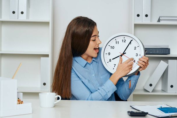 Podnikatelka sedí v kanceláři a ukazuje hodiny  - Fotografie, Obrázek