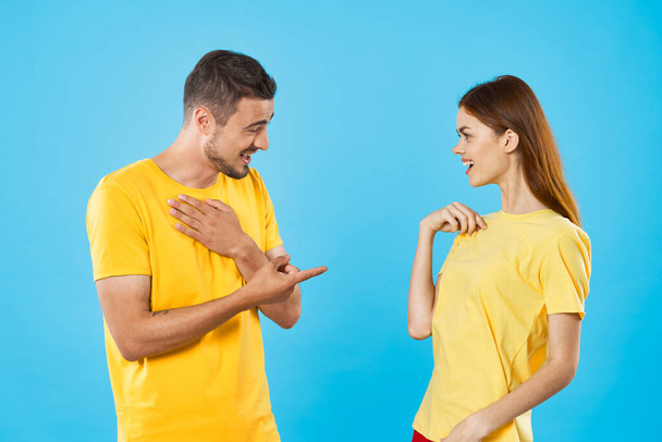 young beautiful couple in  t-shirts posing in studio on isolated background - Photo, Image