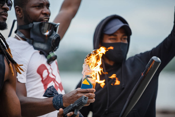 afroamerican men hold burning glass bottle in hands - Photo, image