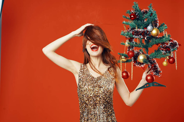 Young woman with Christmas tree in studio - Zdjęcie, obraz