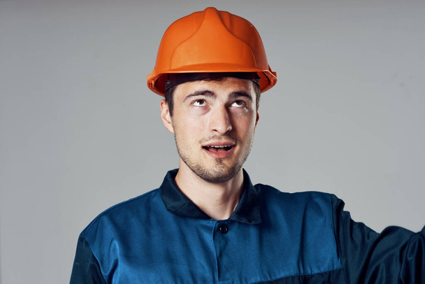 Студийный снимок Промышленный рабочий в оранжевом шлеме смотрит вверх - Фото, изображение