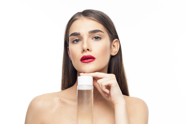 Studio shot. Portrait of young beautiful woman with beauty product  isolated on white background - Photo, Image