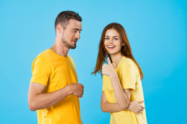 young beautiful couple in  t-shirts posing in studio on isolated background - Φωτογραφία, εικόνα